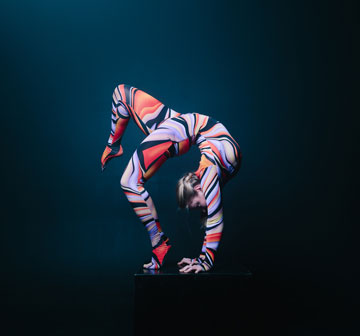 Contorcionista mostrando o equilíbrio e flexibilidade do corpo.
