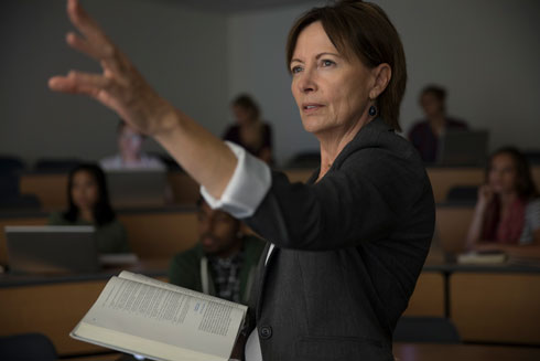 Professor ministrando aula em um auditório.